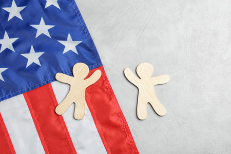 Flat lay composition with wooden people and USA flag on light backgroundの写真素材