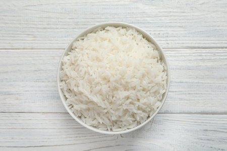 Bowl of tasty cooked rice on white wooden background, top viewの写真素材