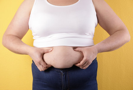 Overweight woman on color background, closeup. Obesity and weight lossの写真素材