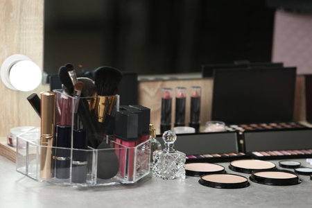 Different makeup products and accessories on dressing table in room interiorの写真素材