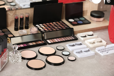 Different makeup products and accessories on dressing table in room interiorの写真素材