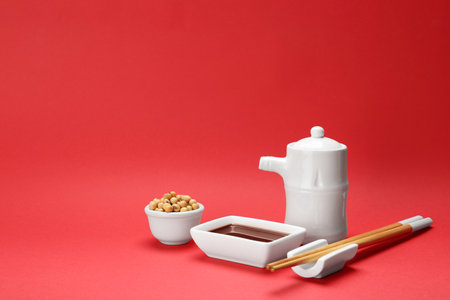 Tableware with soy sauce and beans on color background. Space for textの写真素材