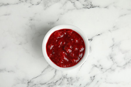 Bowl of cranberry sauce on marble background, top viewの写真素材