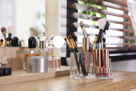 Makeup products and accessories on dressing table against blurred backgroundの写真素材