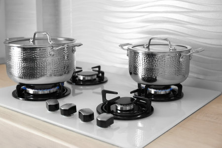 Shiny steel saucepans on modern gas stoveの写真素材