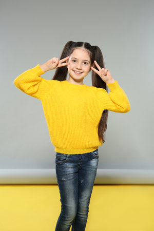 Portrait of little girl posing on gray backgroundの写真素材