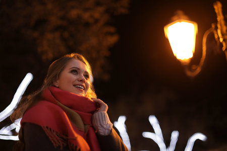 Beautiful young woman spending time in city at nightの写真素材