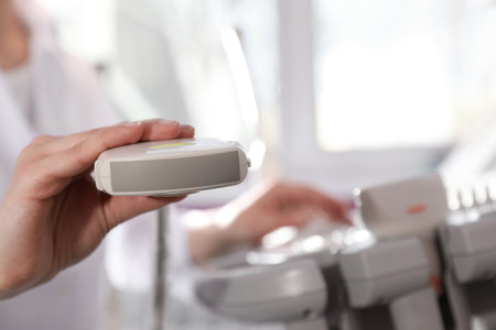Sonographer holding ultrasound machine probe in clinic, closeup with space for textの写真素材