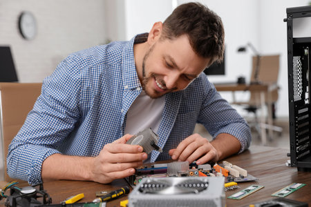 Male technician repairing motherboard at table indoorsの写真素材