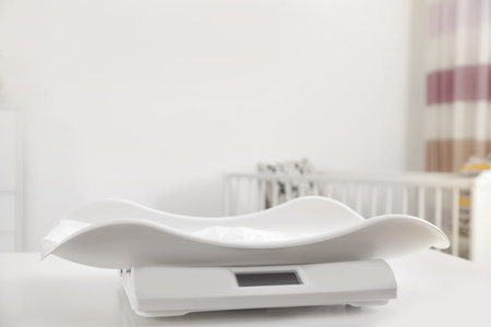 Modern digital baby scales on table in room. Space for textの写真素材