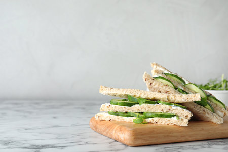 Wooden board with traditional English cucumber sandwiches on table. Space for textの写真素材