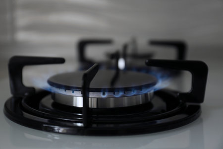 Gas burner with blue flame on modern stove, closeupの写真素材