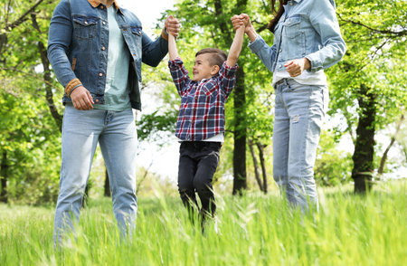 Cute little child having fun with his parents in the park. family weekend