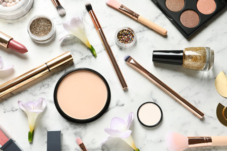 Many different makeup products and spring flowers on marble background, flat layの写真素材