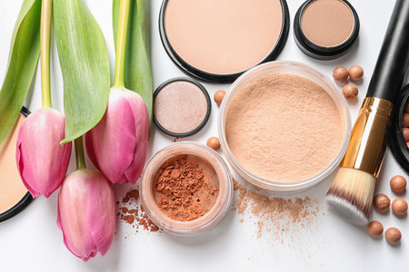Many different makeup products and spring flowers on white background, top viewの写真素材