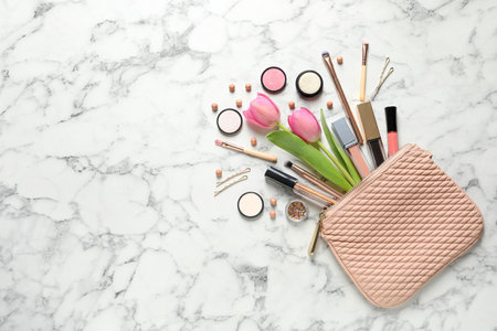 Many different makeup products and spring flowers on marble background, flat lay. Space for textの写真素材
