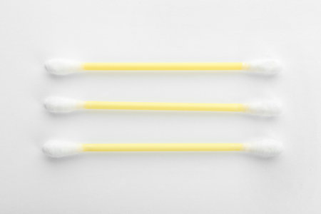 Yellow plastic cotton swabs on white background, top viewの写真素材