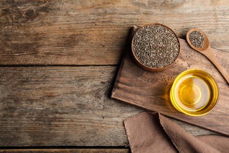 Flat lay composition with chia seeds oil and grains on wooden table. Space for textの写真素材