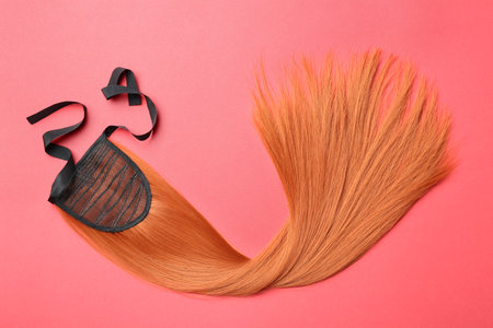 Lock of straight red hair on color background, top viewの写真素材