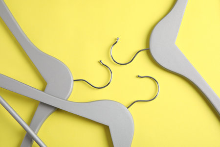 Empty wooden hangers on color background, flat lay