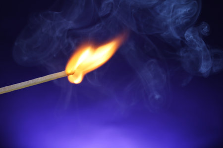Burning matchstick on color background, closeup. Space for textの写真素材