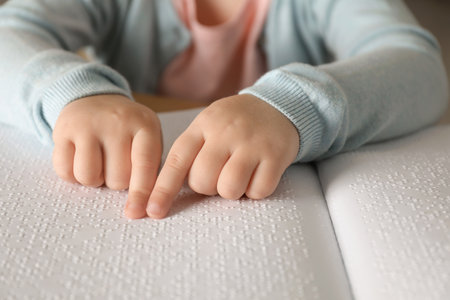 Blind child reading book written in Braille, closeupの写真素材