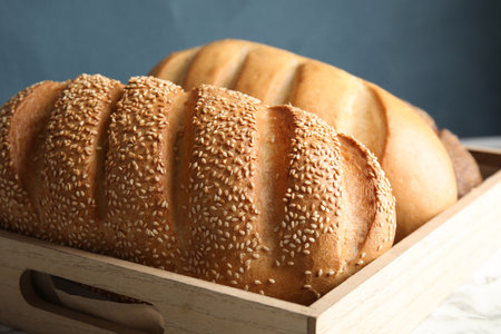 Tray with fresh bread on table, closeup