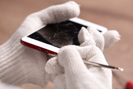 Technician fixing mobile phone at table, closeup. device repair serviceの写真素材