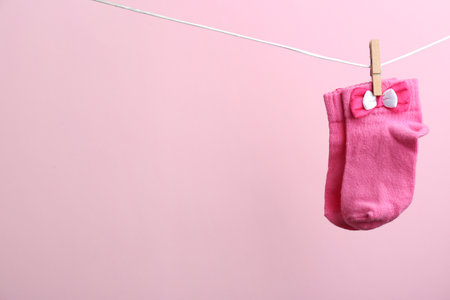 Small socks hanging on washing line against color background, space for text. baby accessoriesの写真素材