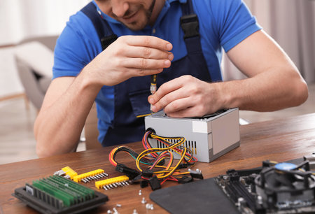 Male technician repairing power supply unit at table indoors, closeupの写真素材