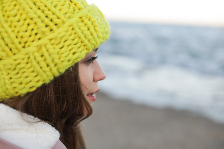 Young woman in warm clothes near the seaの写真素材