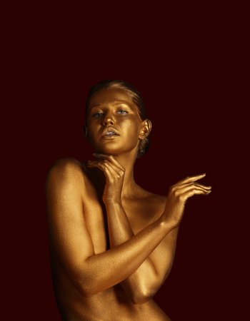 Portrait of beautiful lady with gold paint on skin against color background