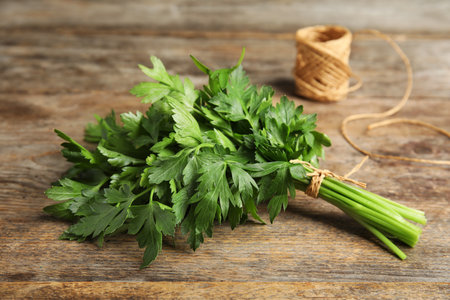 Bunch of fresh green parsley and twine on wooden tableの写真素材