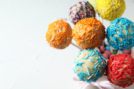 Yummy colorful cake pops on light background, closeup. Space for textの写真素材