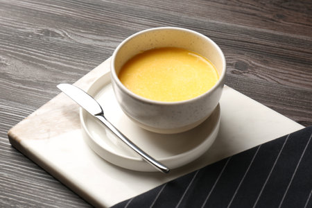 Bowl of melting butter served on wooden tableの写真素材