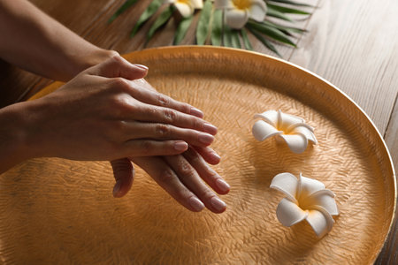 Woman soaking her hands in bowl of water and flowers on table, closeup with space for text. spa treatmentの写真素材
