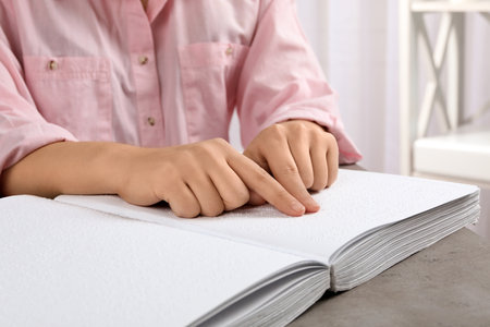 Blind person reading book written in Braille at table, closeupの写真素材