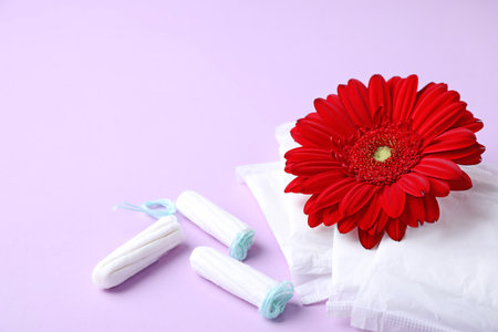 Different feminine hygiene products and flower on color background. Gynecological careの写真素材