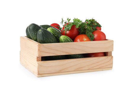 Wooden crate full of fresh vegetables on white backgroundの写真素材