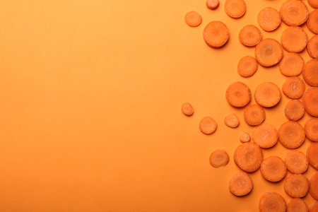 Flat lay composition with carrot slices on color background. Space for textの写真素材