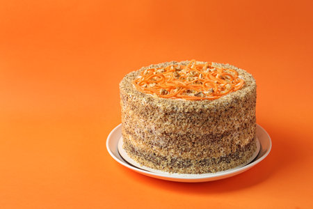 Dish with delicious carrot cake on color background. Space for textの写真素材