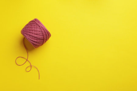 Clew of knitting threads on color background, top view with space for text. Sewing stuff
