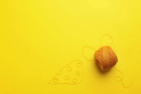Mouse and cheese made of knitting threads on color background, top view with space for text. Sewing...
