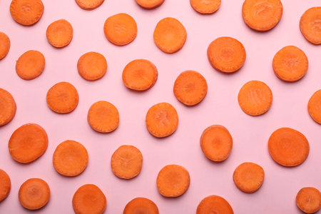 Flat lay composition with fresh carrot slices on color backgroundの写真素材