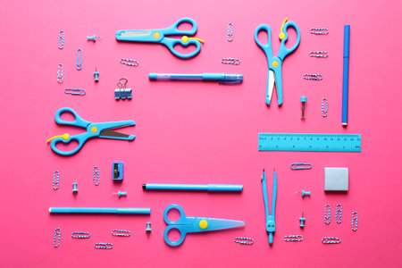 Flat lay composition with scissors and school supplies on color background. Space for text