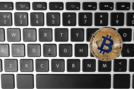 Gold bitcoin on computer keyboard, top view. Space for text