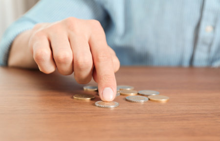 Man counting coins at table, focus on handの写真素材