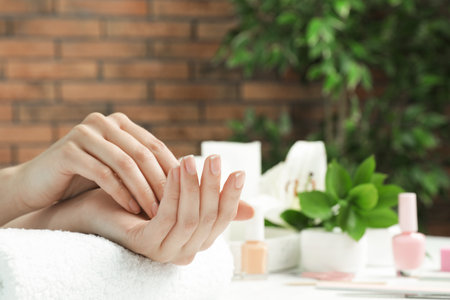 Woman showing smooth hands on towel at table, closeup with space for text. spa treatmentの写真素材