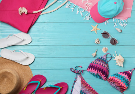 Flat lay composition with swimsuit and beach accessories on wooden background. Space for textの写真素材