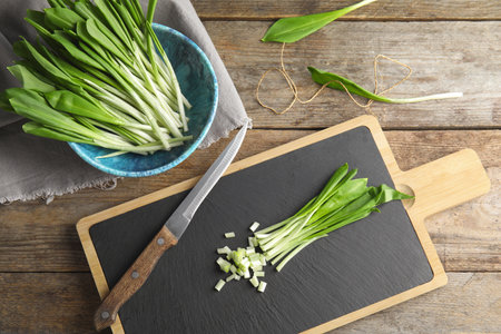 Flat lay composition with wild garlic or ramson on wooden tableの写真素材